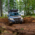Subaru Forester driving through mud puddle offroad