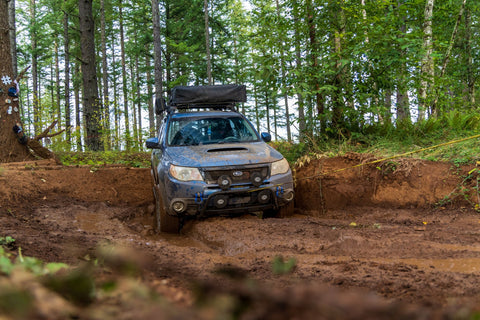 Subaru Forester driving through mud puddle offroad