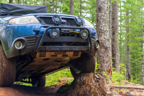 RalliTEK Subaru Forester Flexed onto Stump Showing off Skid Plate and Hidden Winch Mount