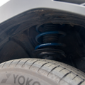 Close-up of a spring installed with RalliTEK branding, focusing on the spring installed on the strut assembly